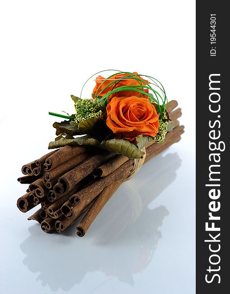 A composition of orange flowers is tied on decorative brown wood and is mirrored on a white background. A composition of orange flowers is tied on decorative brown wood and is mirrored on a white background