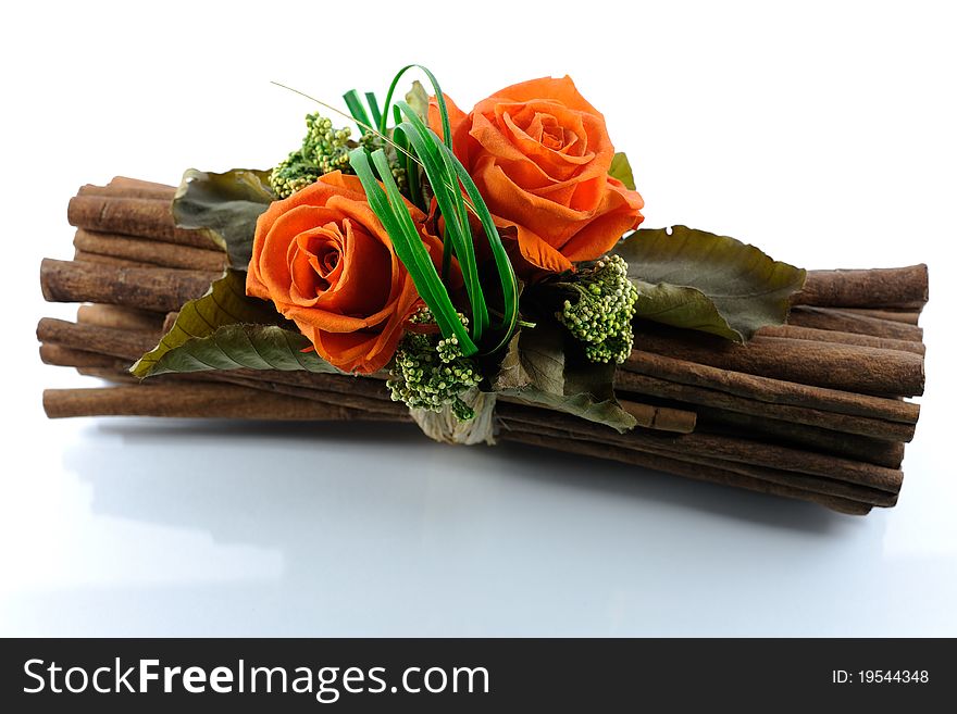 A composition of orange flowers is tied on decorative brown wood and is mirrored on a white background. A composition of orange flowers is tied on decorative brown wood and is mirrored on a white background