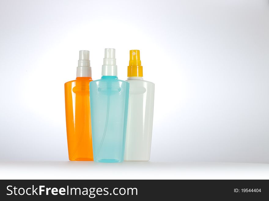 Colorful cosmetic sprays on a light gray background. Horizontal image