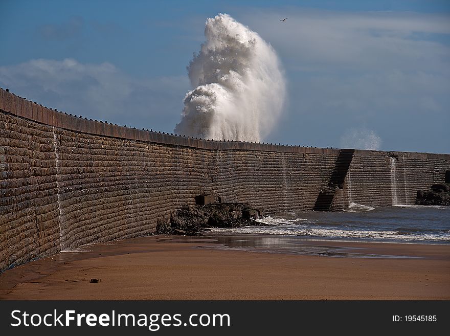 Wave splash against the pier wall in Seaham UK, illustrating the power of water. Wave splash against the pier wall in Seaham UK, illustrating the power of water