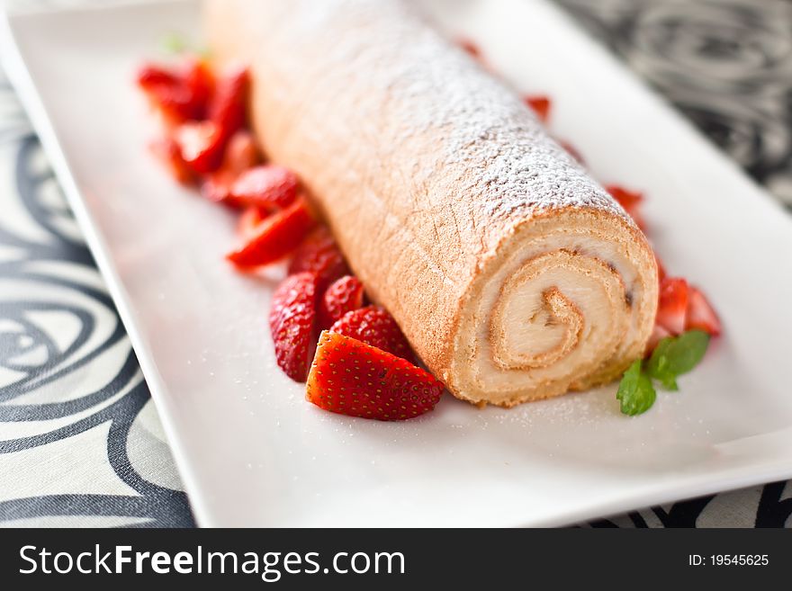 Homemade cream roulade decorated with fresh strawberries