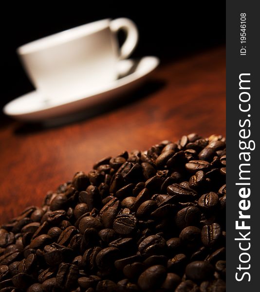 Coffee grain and cup on wooden table