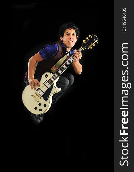 Portrait of young trendy guy jumping with electric guitar isolated on black