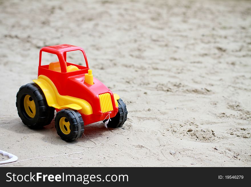 Little red toy car in sandbox