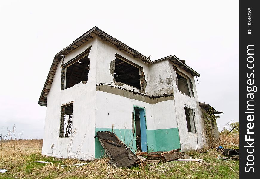 Crumbling abandoned house standing alone in the field