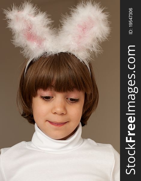 Studio portrait of smiling cute little girl wearing bunny ears on brown background. Studio portrait of smiling cute little girl wearing bunny ears on brown background