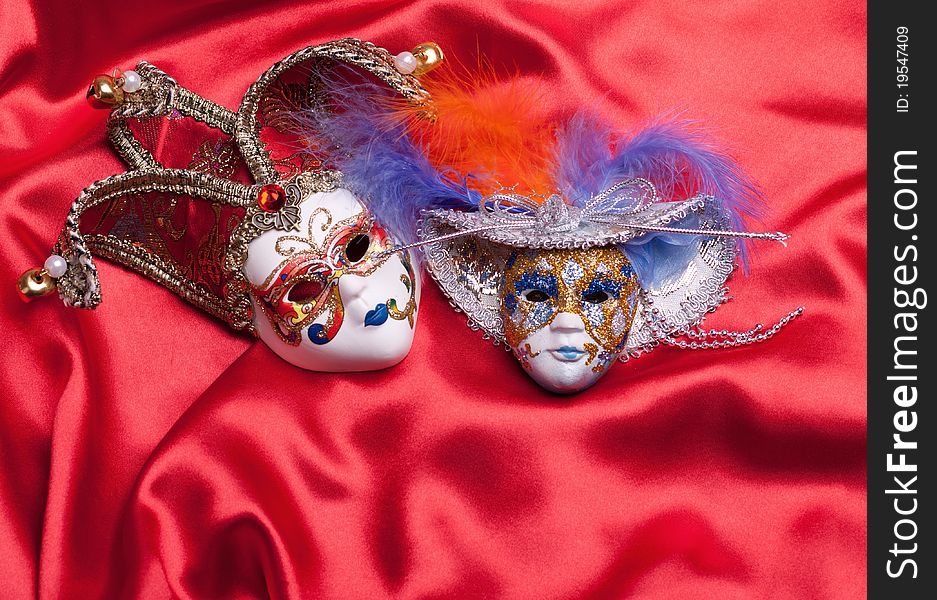 Two venetian mask on a red silk