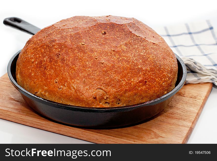 Homemade bread in frying pan on the desk on white background with towel