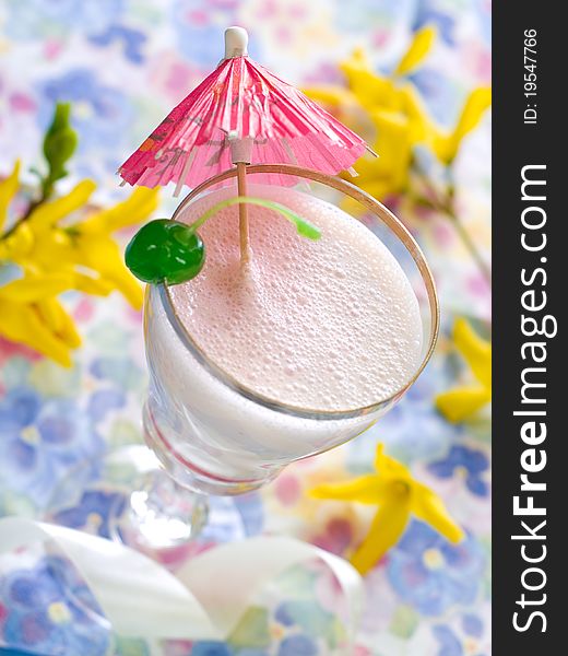 Vanilla milkshake with cherry garnish with shallow depth of field.