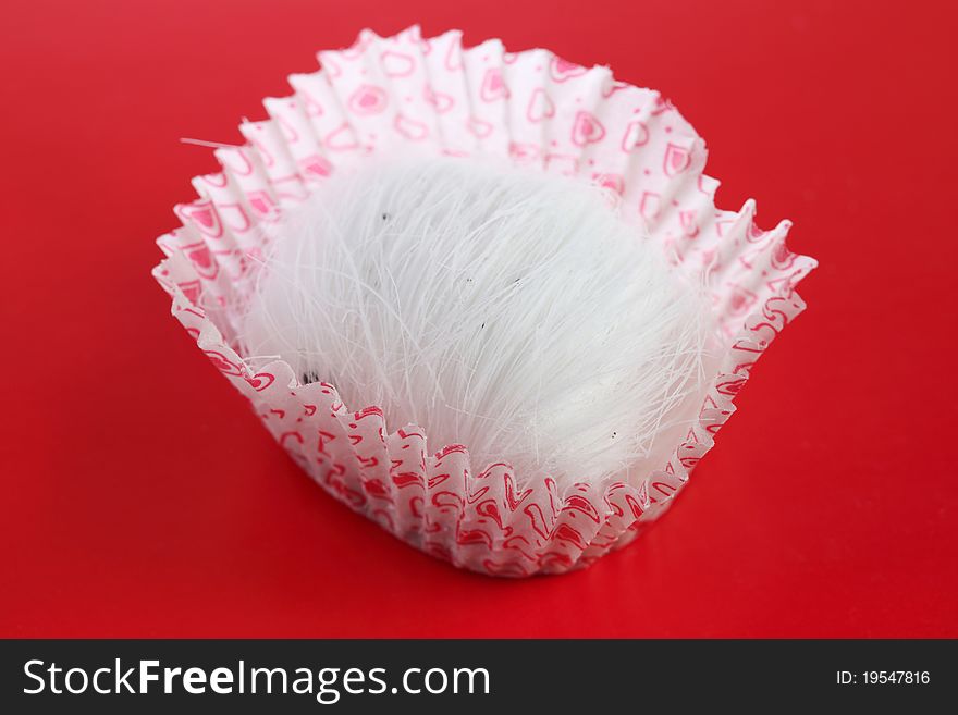 A dragon beard candy on red background.