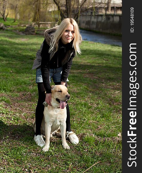 Outdoor shot of beautiful cheerful woman with dog in the park. Outdoor shot of beautiful cheerful woman with dog in the park