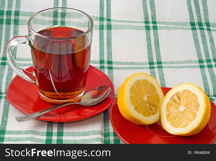 Cup of tea and lemon on a red saucer