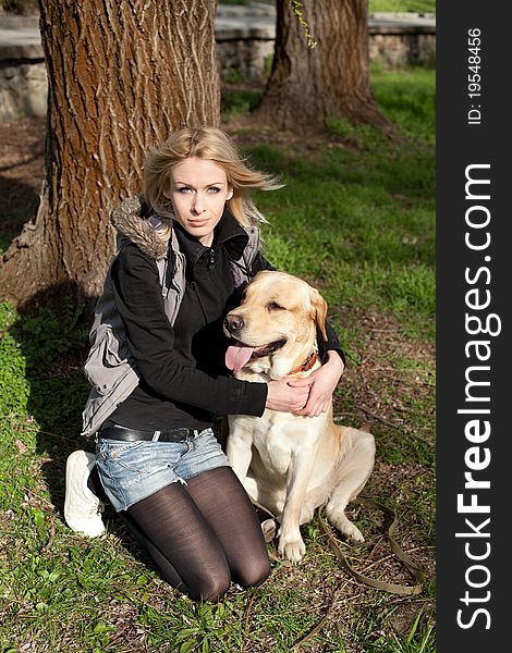 Outdoor shot of beautiful cheerful woman with dog in the park. Outdoor shot of beautiful cheerful woman with dog in the park