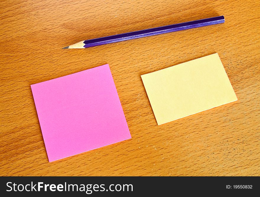 Yellow and pink memo with pencil on table