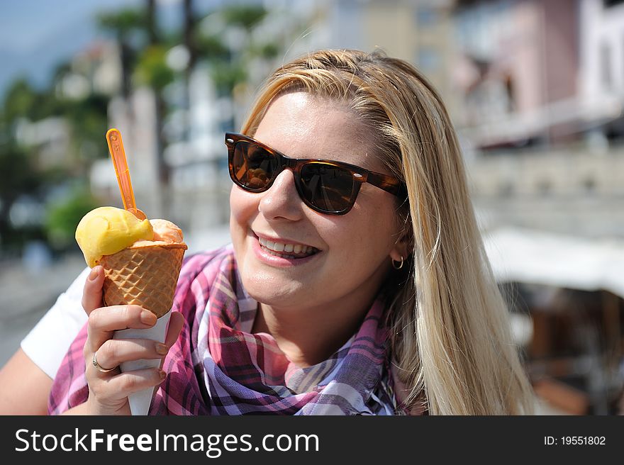 Pretty casual summer girl eating ice cream outdoors