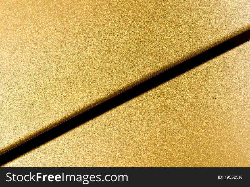 Glittering golden vehicle panel closeup abstract. Glittering golden vehicle panel closeup abstract