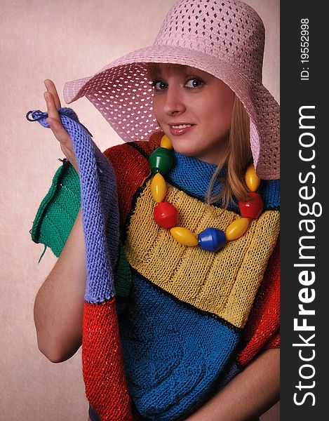 Funny Girl in a big hat and a multicolored knitted cape