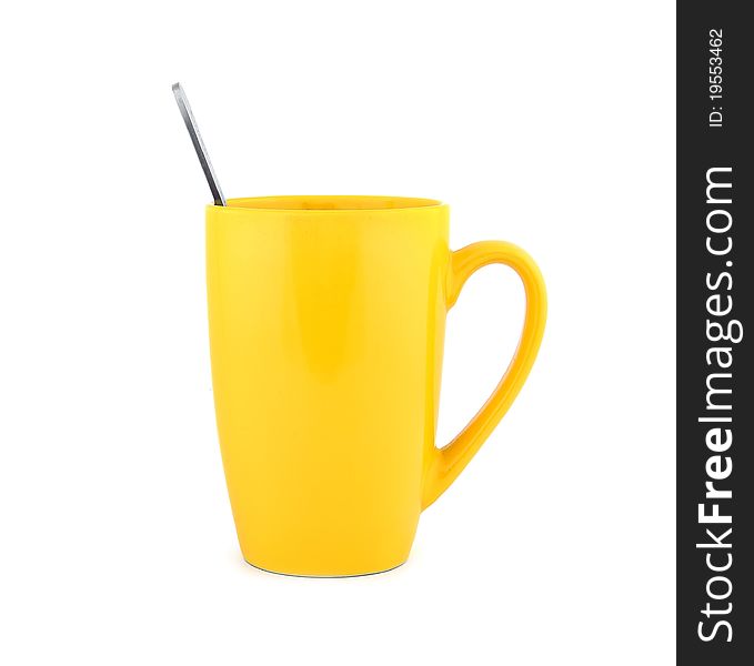Empty yellow cup and spoon on a white background