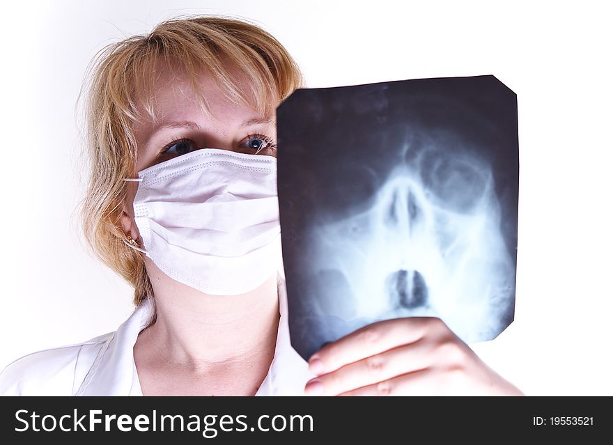 Serious female doctor looking at a x-ray against white background