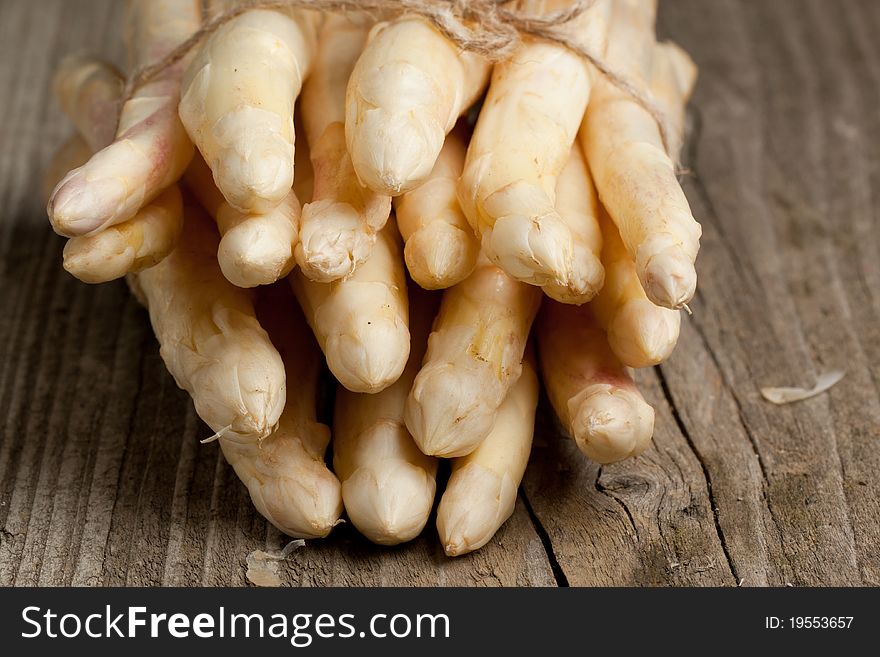 Bunch of fresh white asparagus on old wooden table