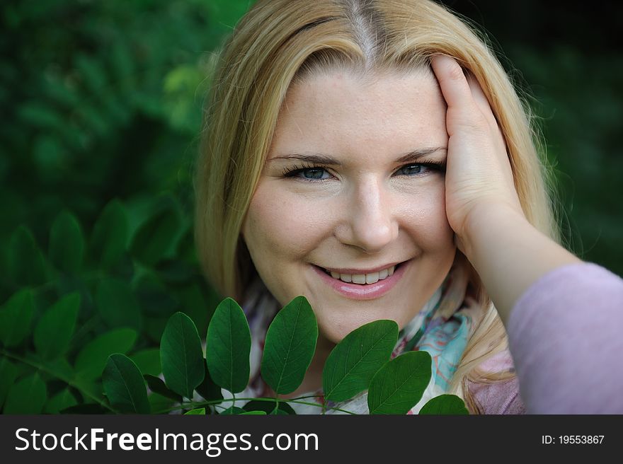 Pretty casual woman outdoors in green park smiling