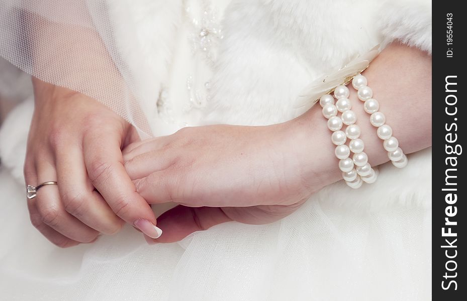 Bride's hands with ring and pearls