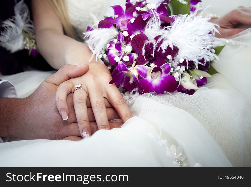 Hands and rings on wedding bouquet. Hands and rings on wedding bouquet