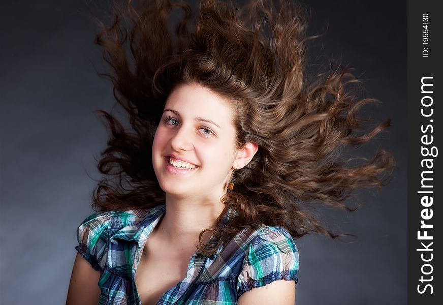 Young brunette woman with long flying hair, studio shot