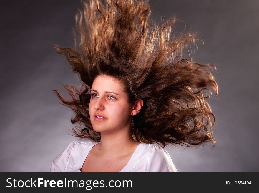 Young brunette woman with long flying hair, studio shot