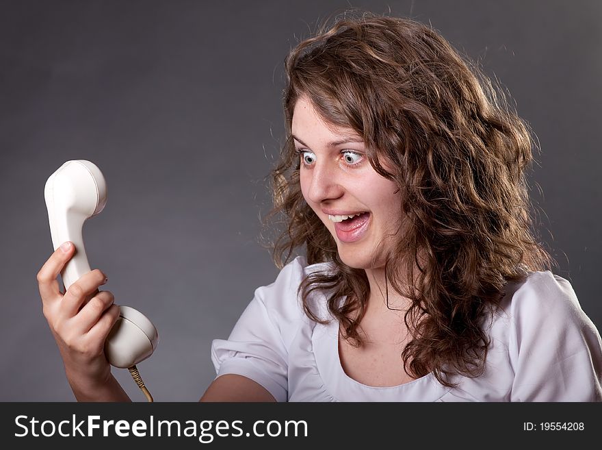 Woman talking on old phone with hair in the air. Woman talking on old phone with hair in the air