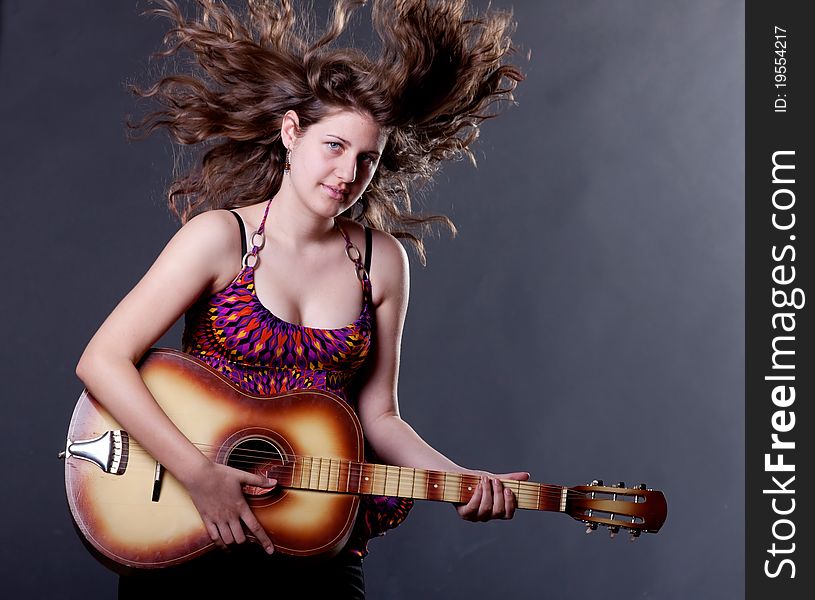 Young girl with long hair playing guitar. Young girl with long hair playing guitar