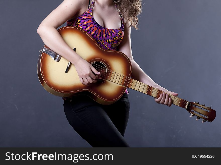 Young girl with playing guitar against blue background. Young girl with playing guitar against blue background