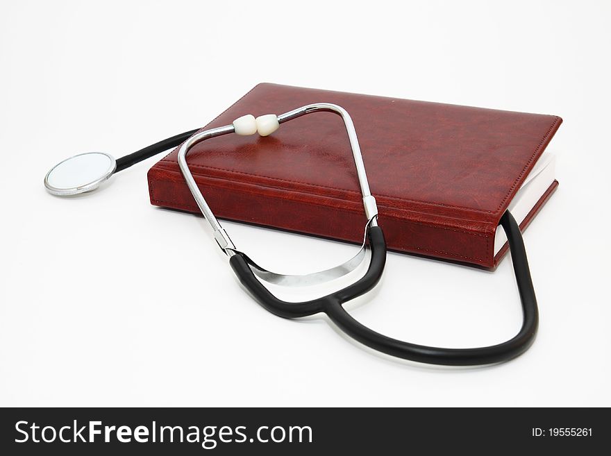 Stethoscope and note-book on white background