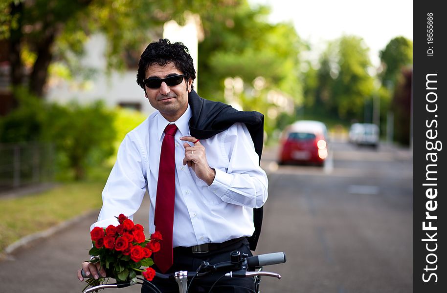 Businessman with bouquet of red roses holding a jacket on a shoulder. Businessman with bouquet of red roses holding a jacket on a shoulder