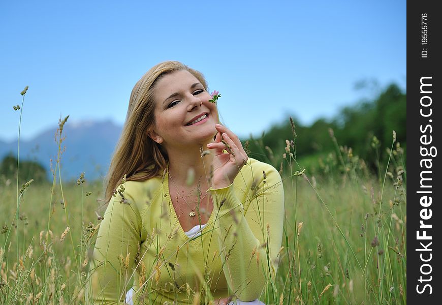 Pretty healthy summer woman outdoors on green field in Alps enjoying freedom. Switzerland. Pretty healthy summer woman outdoors on green field in Alps enjoying freedom. Switzerland