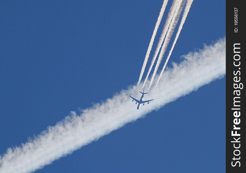 A large four-engined jet hits a vaportrail in the sky. A large four-engined jet hits a vaportrail in the sky