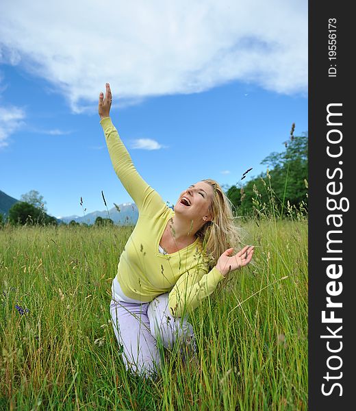 Pretty healthy summer woman outdoors on green field in Alps enjoying freedom. Switzerland. Pretty healthy summer woman outdoors on green field in Alps enjoying freedom. Switzerland