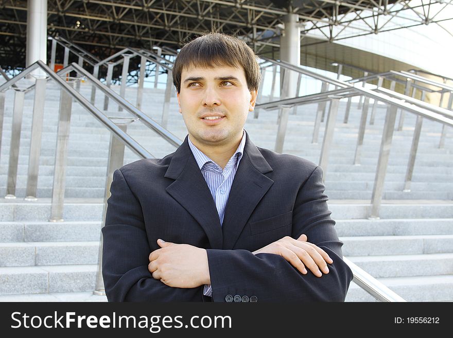 Closeup of a young businessman outdoors arms crossed on his chest