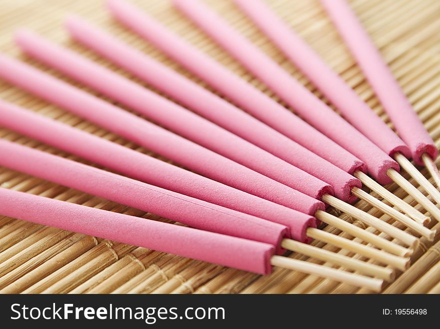 Spa treatment in bright pink palette, and arotatizirovannye sticks on a wooden bamboo rug