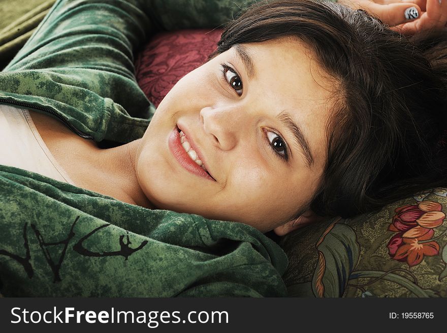 A happy young teen relaxed on multiple throw pillows. A happy young teen relaxed on multiple throw pillows.