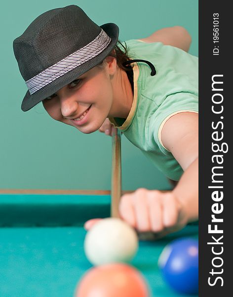 Young woman in hat playing billiards. Young woman in hat playing billiards