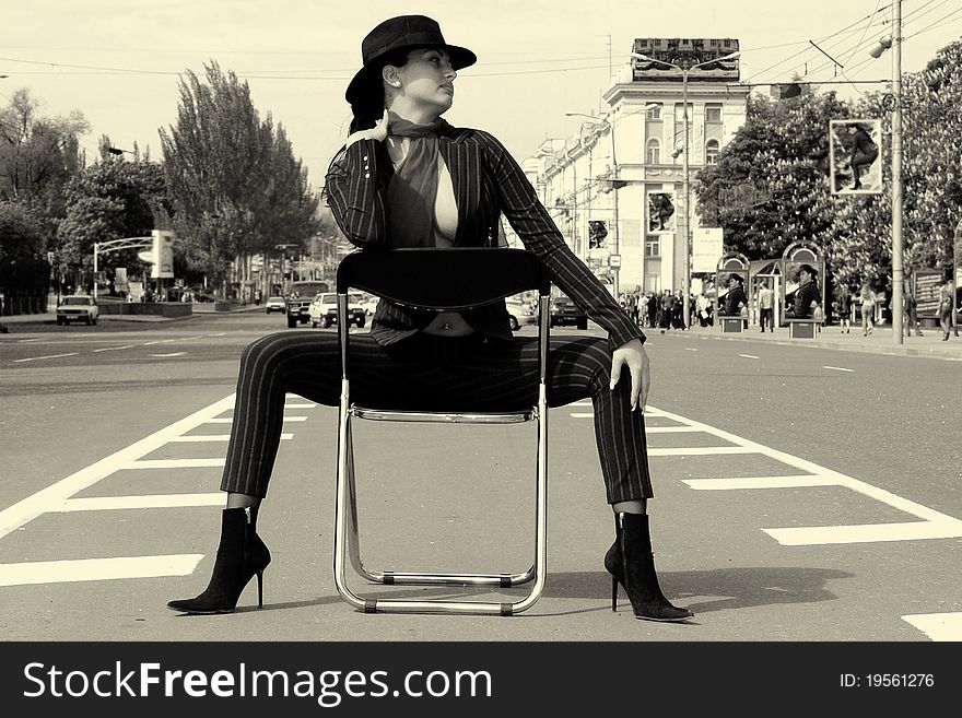 Woman In A Suit Sitting On A Chair On A Highway