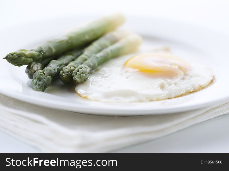 Asparagus with eggs on white plate