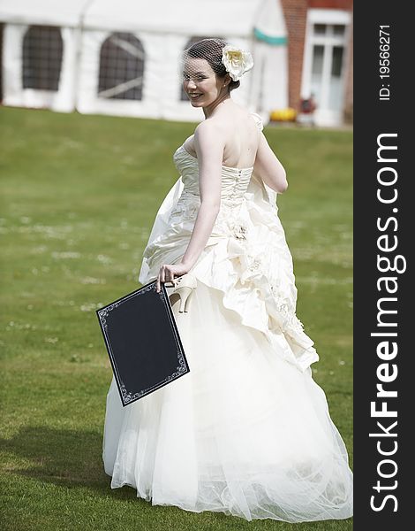 Pretty bride in wedding dress holding a blank board with space for copy. Pretty bride in wedding dress holding a blank board with space for copy