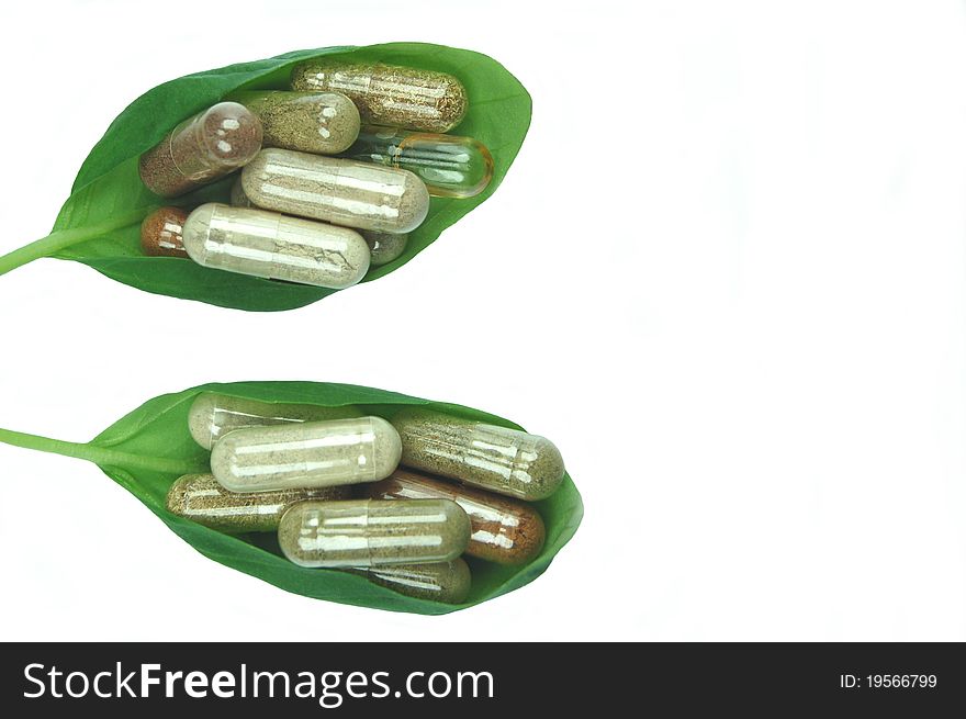 Herbal capsules in green basil leaves. Herbal capsules in green basil leaves