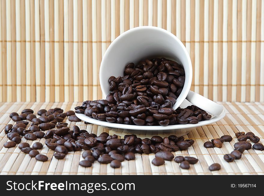 White cup and saucer with coffee beans. White cup and saucer with coffee beans