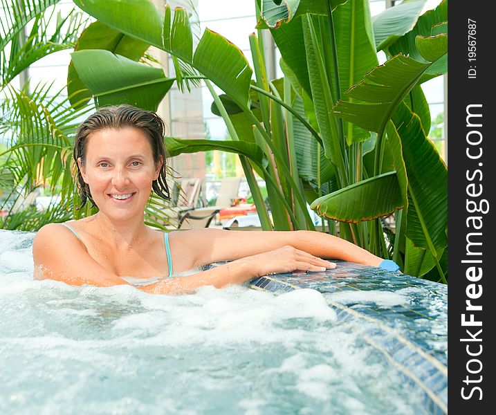 An attractive happy young woman spends relaxing in the Jacuzzi. An attractive happy young woman spends relaxing in the Jacuzzi
