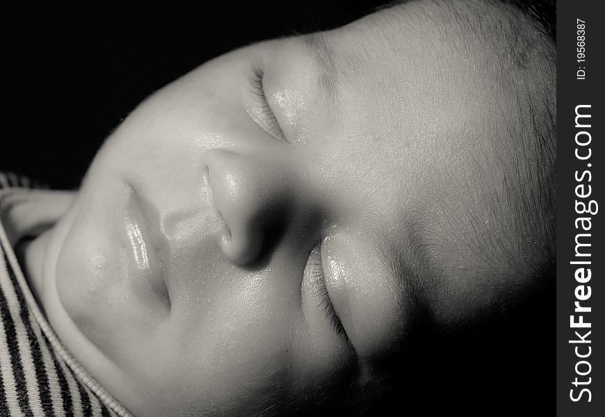 Very beautiful male baby sleeping and dreaming, little face of baby born, closed eyes