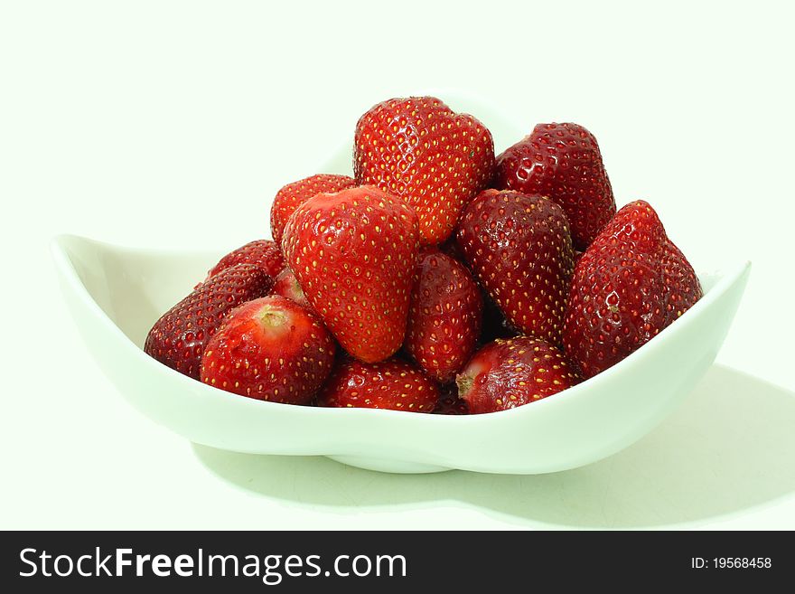 Strawberries in a china plate on a white background