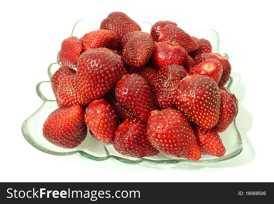 A glass plate with strawberries on a white background. A glass plate with strawberries on a white background